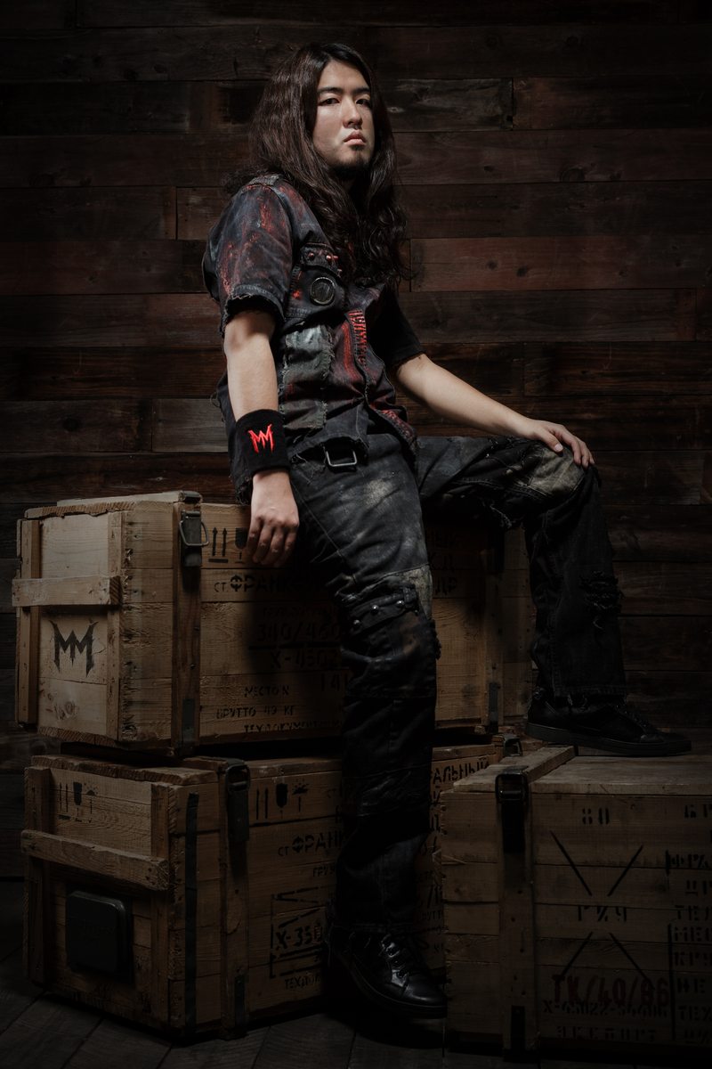 Masaki Murashita posing beside wooden crates in a portrait session