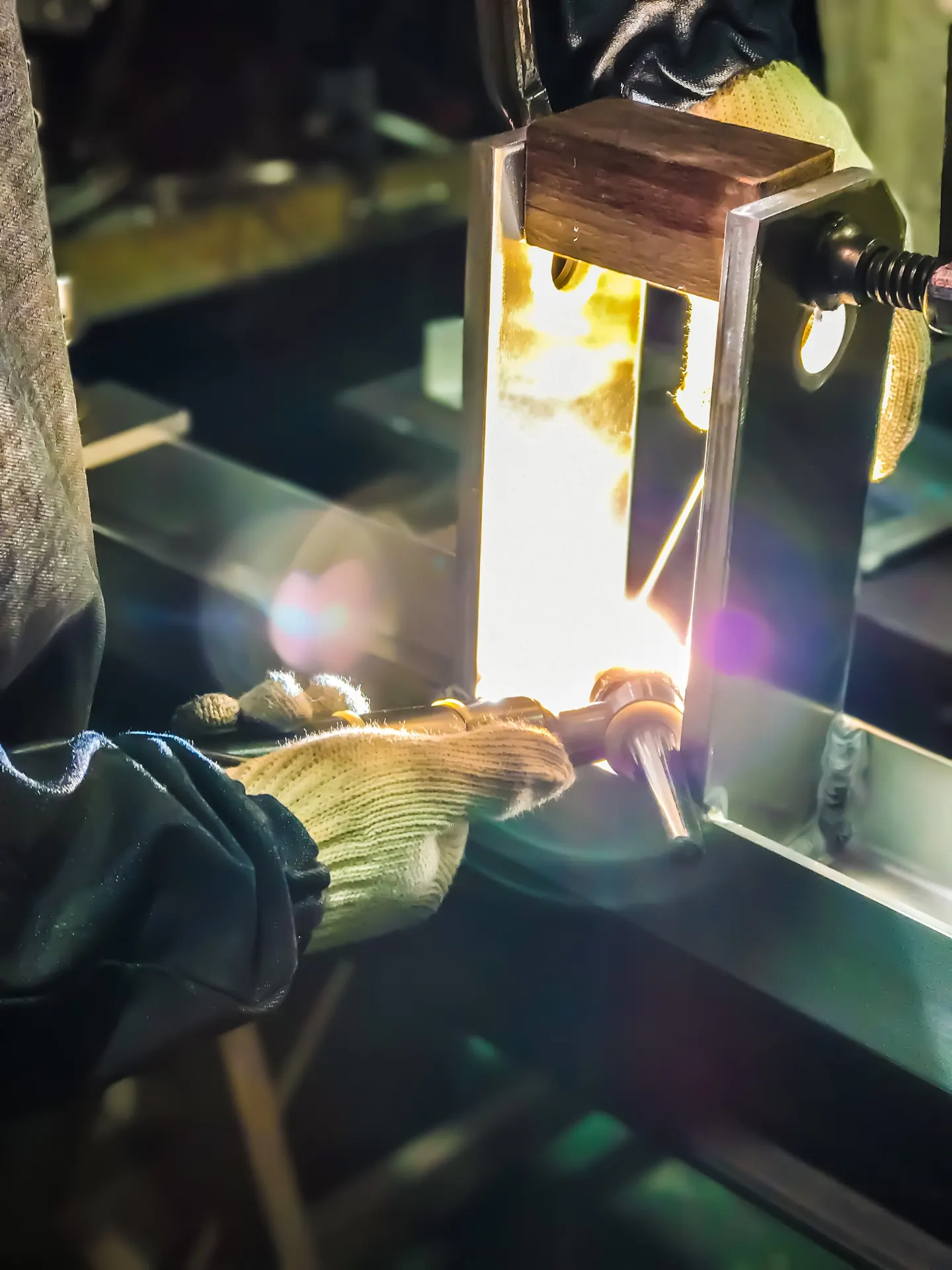 Welding metal held in a fixture at a precision sheet metal workshop in Japan