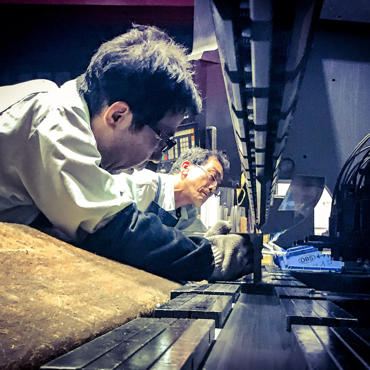 Two people carefully checking their work at a sheet metal fabrication machine